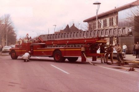 Old Fire Truck With Fighters Pulling Out Hose
